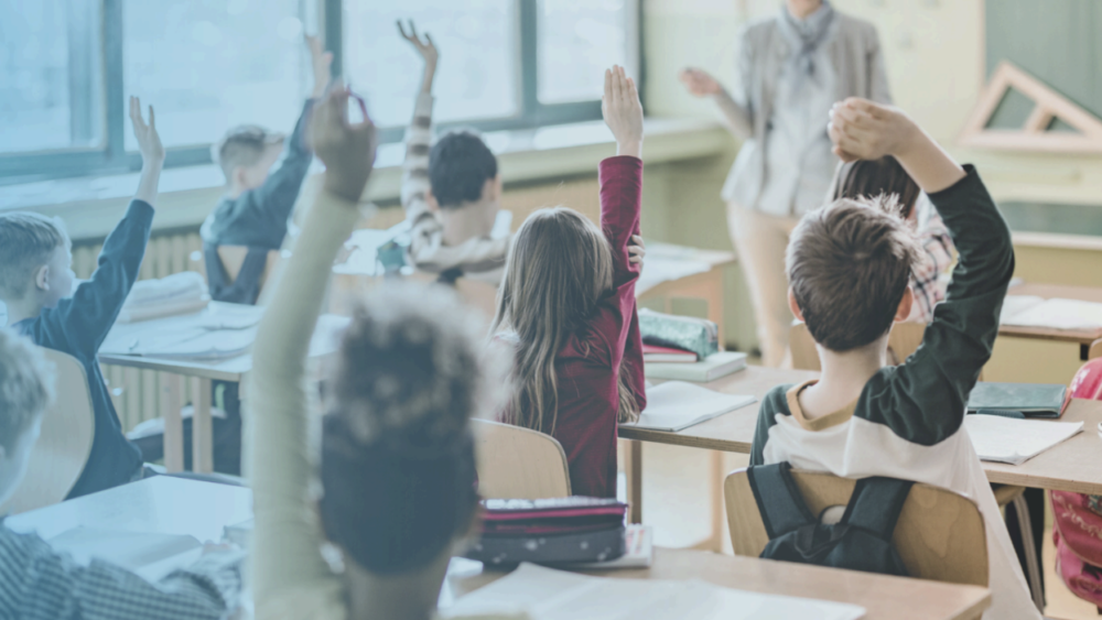 Classroom with children raising hands